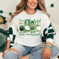 A woman wearing a white t-shirt with a graphic of cartoon ducks and the text "Just a lucky goose" is sitting on a couch.