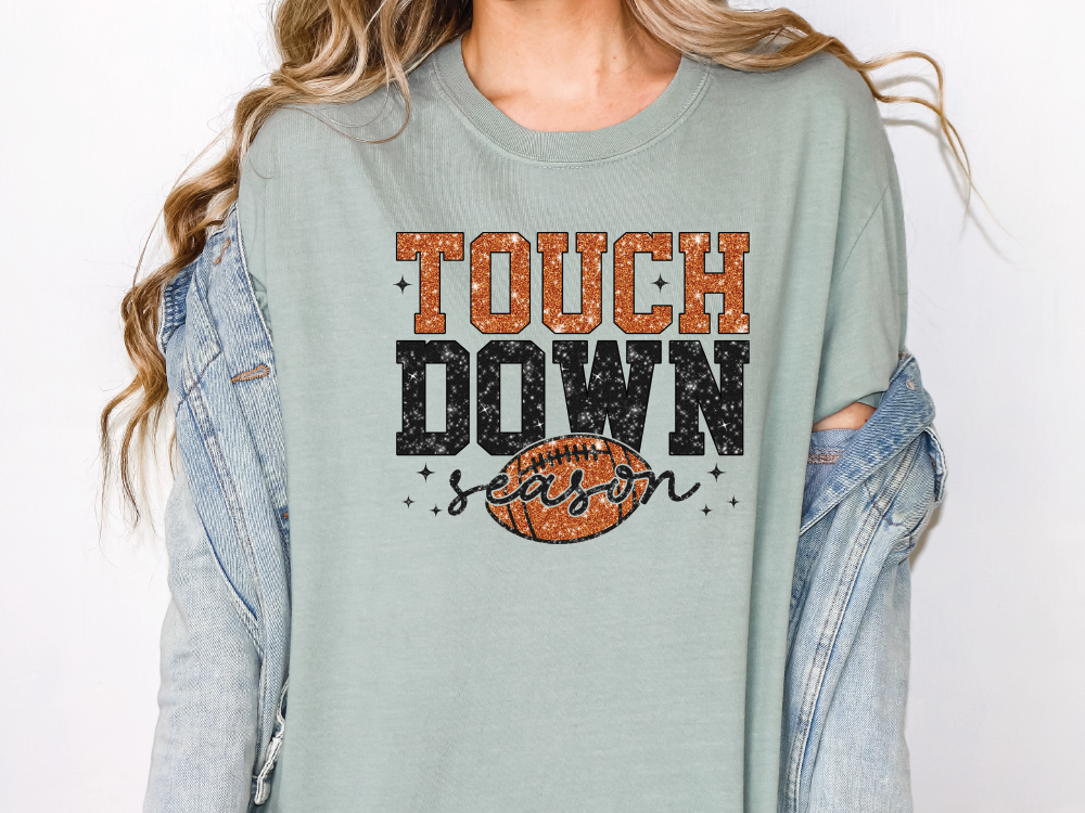 a woman wearing a t - shirt with the words touch down on it