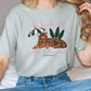 a woman sitting on a bed wearing a t - shirt with a tiger on it