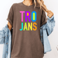 A person wearing a brown t-shirt with the text "TRO JANS" in a colorful font, paired with a denim jacket.
