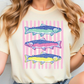 A woman wearing a white t-shirt with a colorful graphic of three fish swimming in a striped pattern.