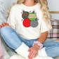 a woman sitting on a couch wearing a merry christmas shirt