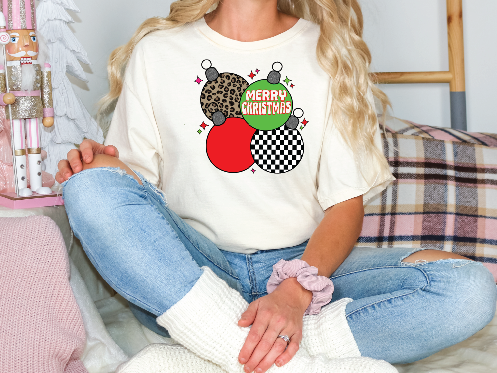 a woman sitting on a couch wearing a merry christmas shirt