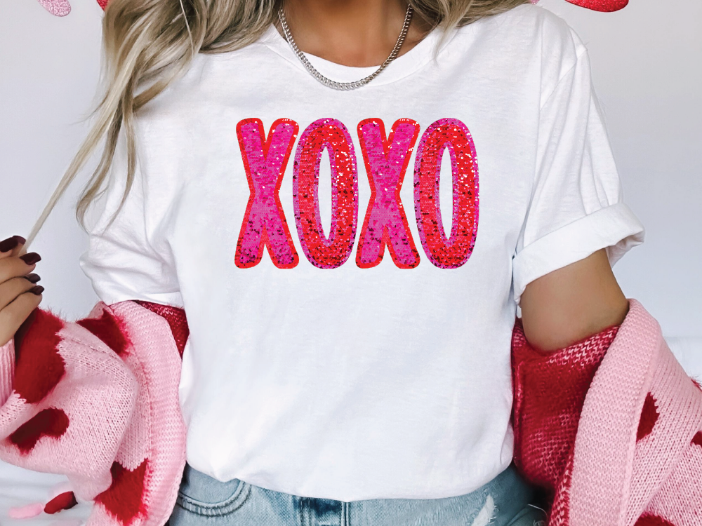 a woman wearing a white shirt with the word xoxo printed on it