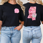 two women wearing black shirts with pink letters on them