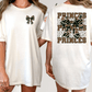A woman wearing a white t-shirt with a camouflage print and the text "PRINCES" printed on the back.