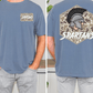 a man wearing a blue t-shirt with a graphic design on the back. The design features a helmet with a plume and the word "SPARTANS" written below it.