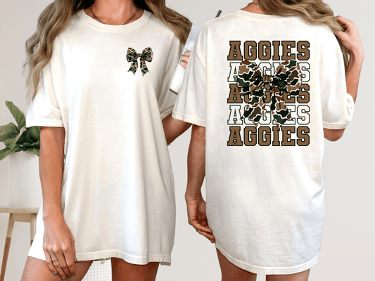 A woman wearing a white t-shirt with a bow and the word "Aggies" printed on the back.