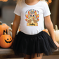 a little girl wearing a white shirt with a turkey on it