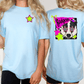 two women wearing light blue t-shirts with a graphic design on the back. The design features a dog's face wearing sunglasses and a star.