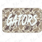 A camouflage-patterned sticker or decal with the word "GATORS" written in a bold, stylized font.