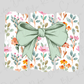 A green bow is placed in the center of a floral patterned background.