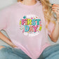 a woman wearing a pink shirt with the words happy first day of school on it