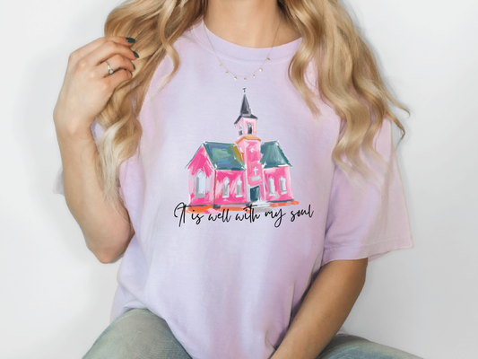 a woman wearing a pink t - shirt with a pink church on it