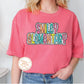 a woman wearing a pink shirt with the words smile, grow, eat, and