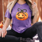 a woman wearing a purple shirt with a pumpkin on it