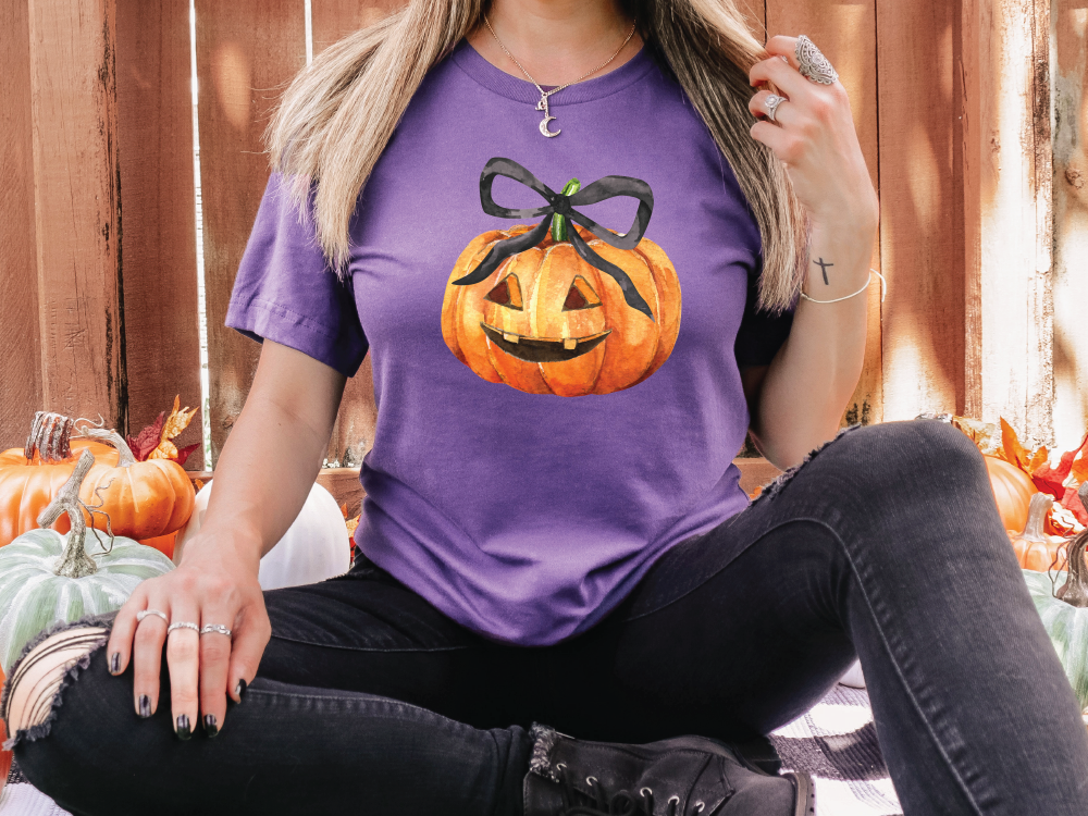 a woman wearing a purple shirt with a pumpkin on it