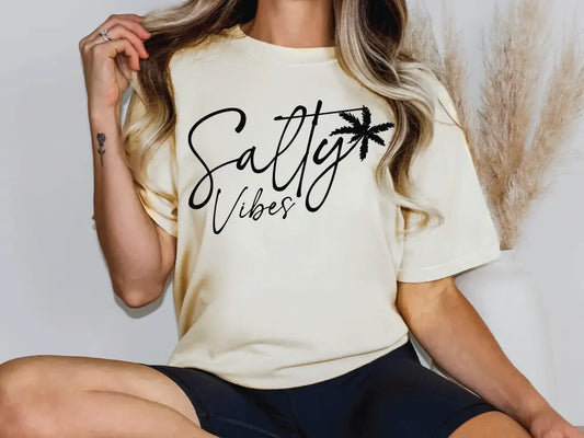 a woman sitting on a chair wearing a shirt that says salty vibes