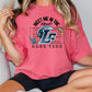 A woman wearing a pink t-shirt with a graphic design on it.