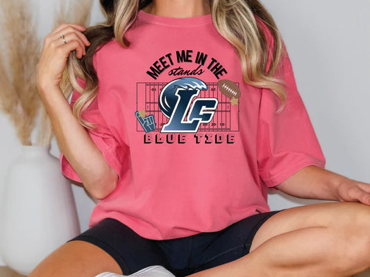 A woman wearing a pink t-shirt with a graphic design on it.
