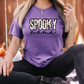 a woman sitting on the ground wearing a spooky mama shirt