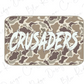 A camouflage-patterned rectangular object with the word "CRUSADERS" written in a stylized, distressed font.