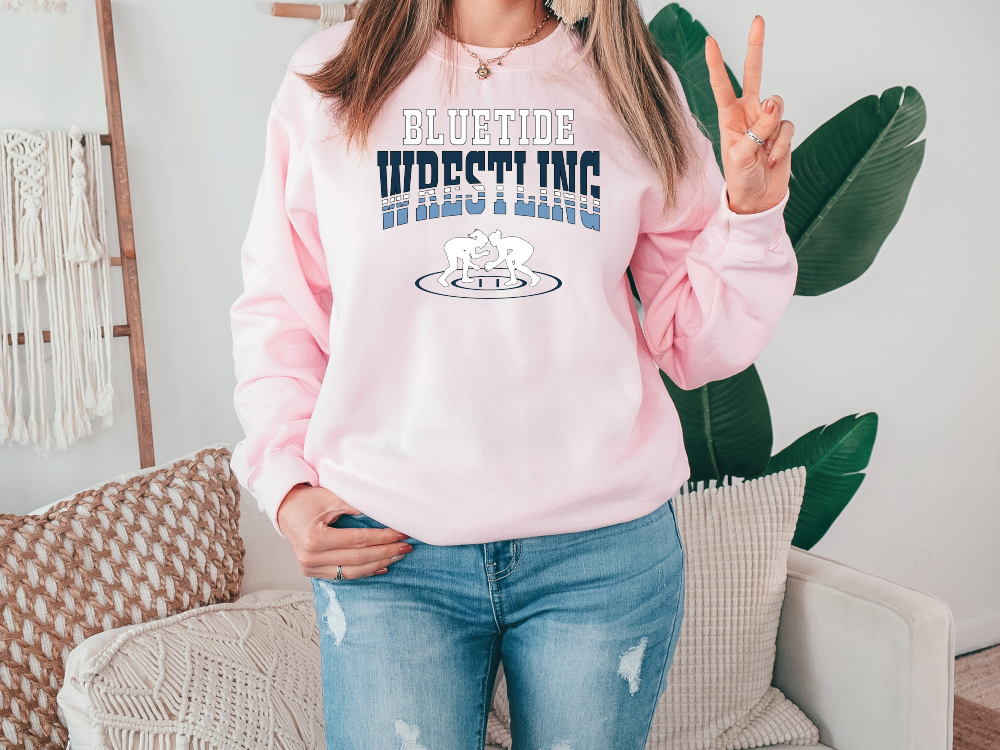 a woman in a pink sweatshirt is standing in front of a couch