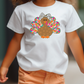 a little girl walking down a street wearing a turkey t - shirt