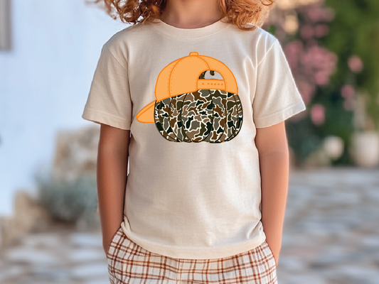 A child wearing a white t-shirt with an orange baseball cap and a camouflage pattern printed on it.