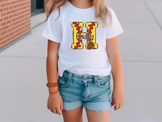 a little girl standing on a sidewalk with a skateboard