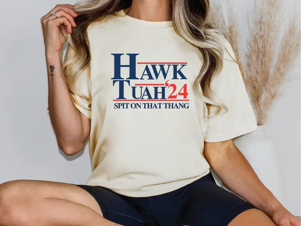 a woman sitting on a chair wearing a hawk utah t - shirt