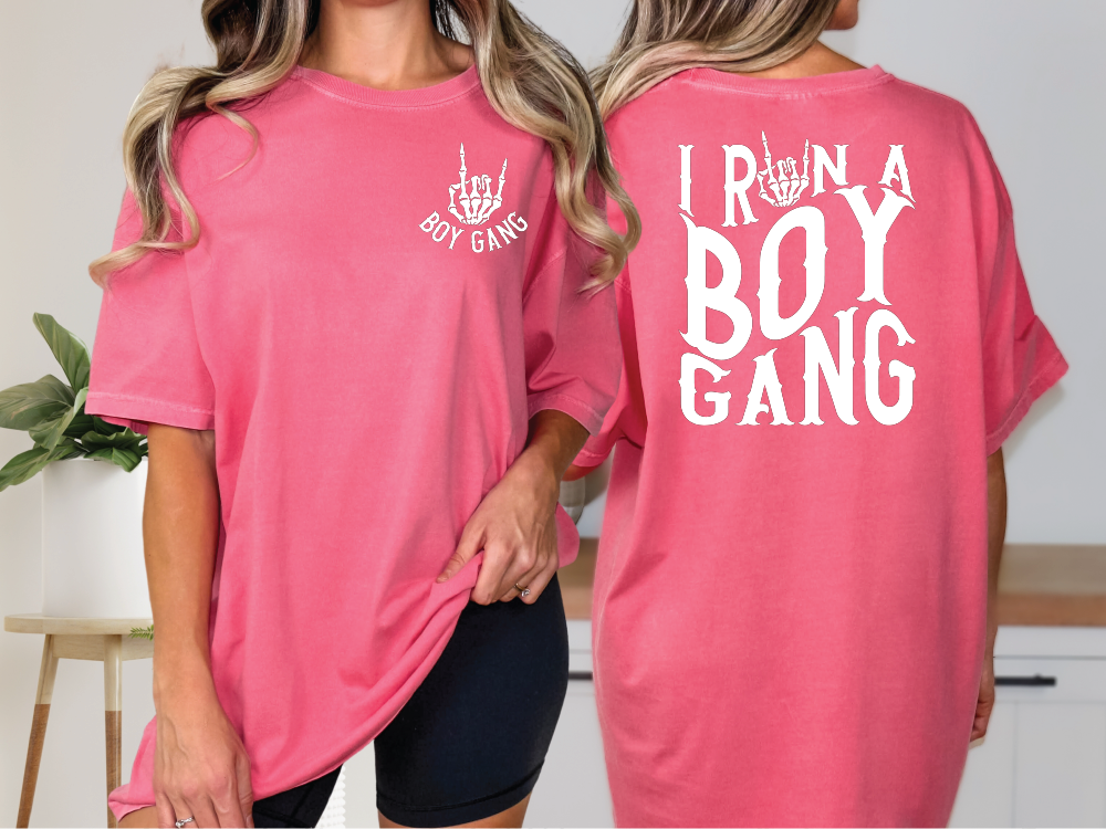 two women wearing pink shirts that say i run a boy gang