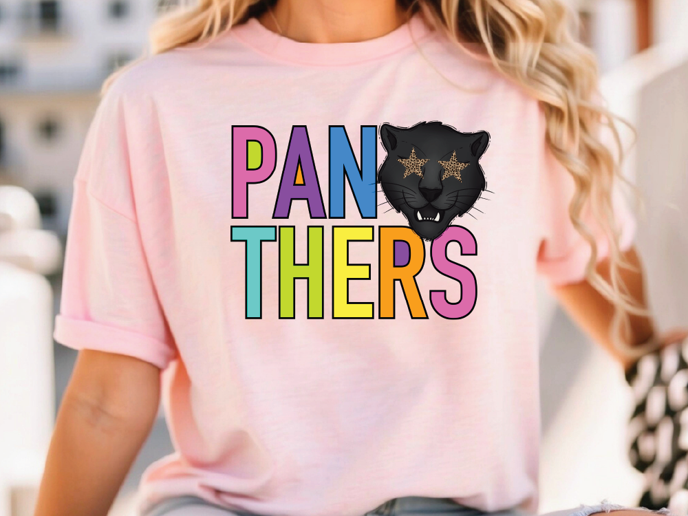 A woman wearing a pink t-shirt with the text "PANTHERS" and a graphic of a panther's face with stars on its eyes.