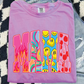 A pink t-shirt with the word "MAMA" printed on it, featuring colorful and abstract designs.