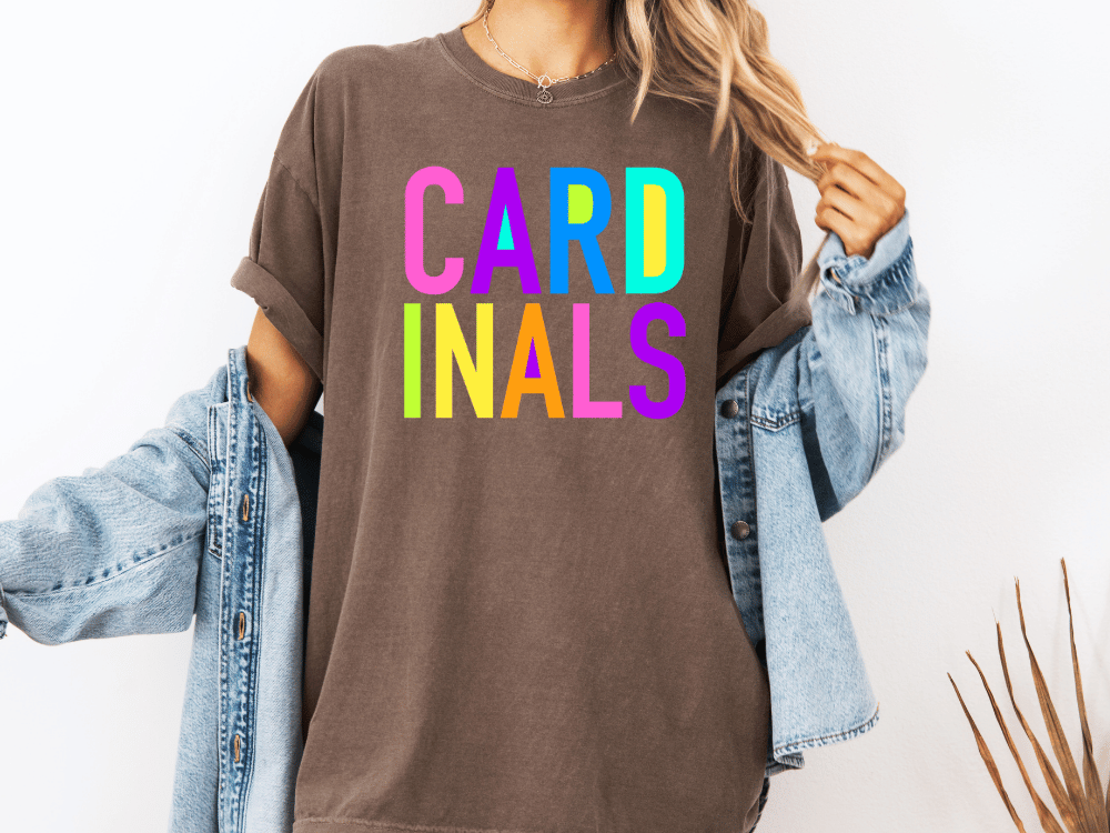 A person wearing a brown t-shirt with the word "CARD" in colorful letters and a denim jacket.