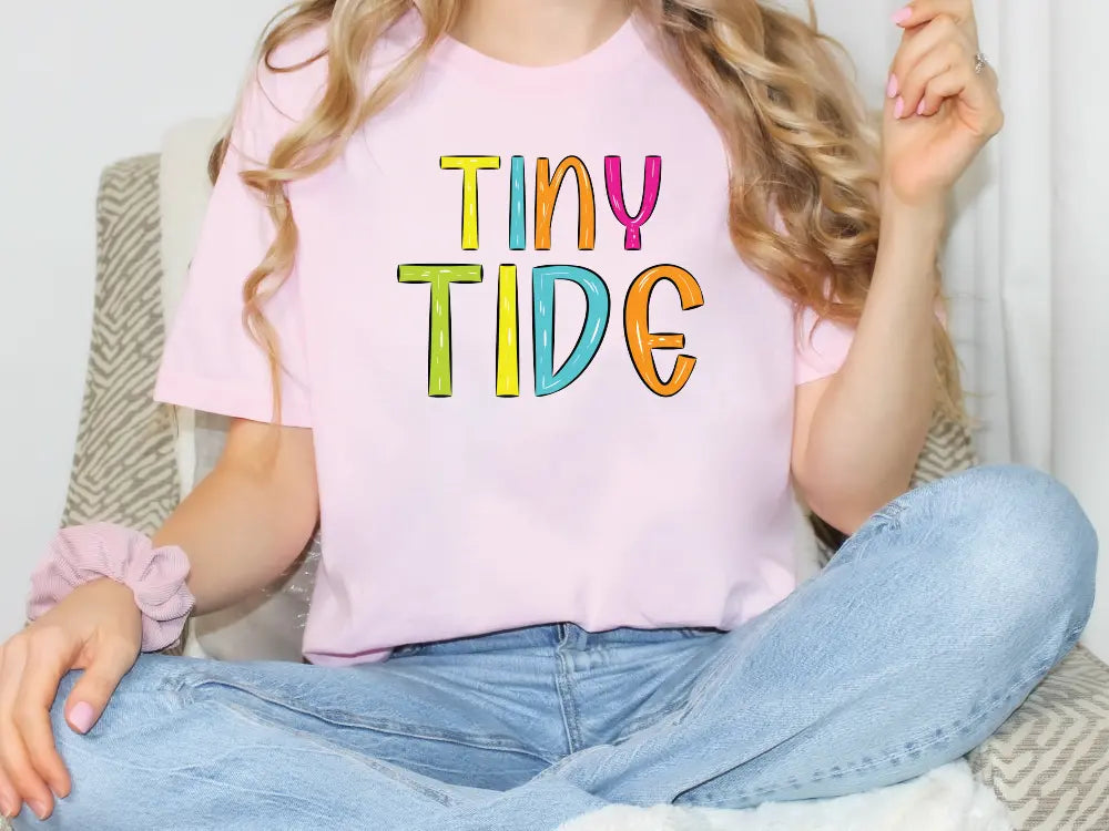 a girl sitting on a couch wearing a tiny tide shirt