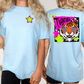 A woman wearing a light blue t-shirt with a graphic design of a tiger wearing sunglasses and surrounded by colorful stars.