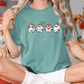 a woman sitting on a bed with three cows on her shirt