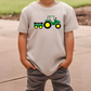 a young boy wearing a t - shirt with a tractor on it