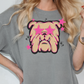 A woman wearing a gray t-shirt with a graphic design of a bulldog and pink stars on it.
