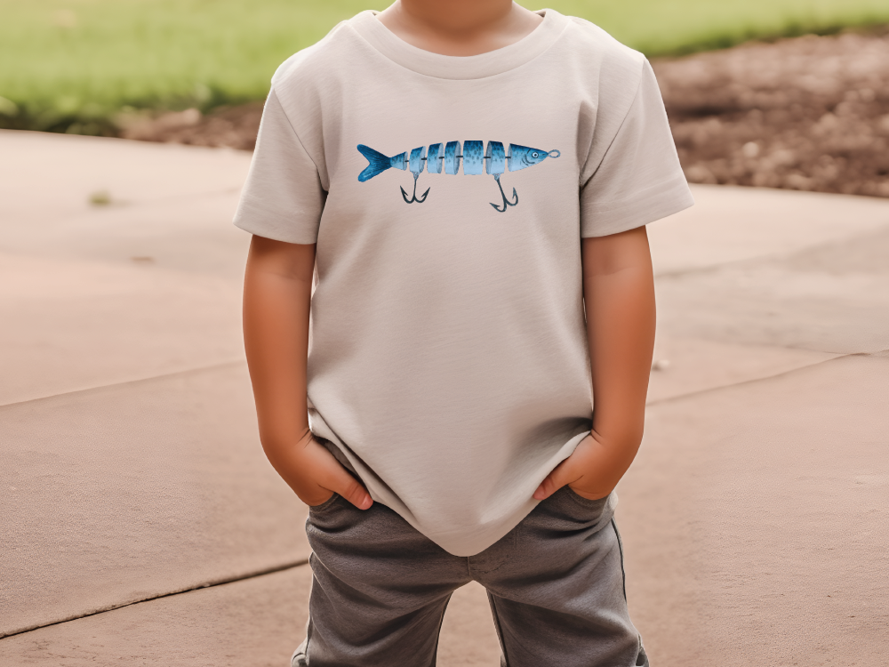 a young boy wearing a t - shirt with a fish on it