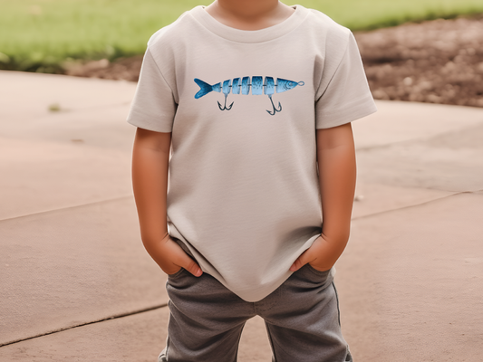 a young boy wearing a t - shirt with a fish on it