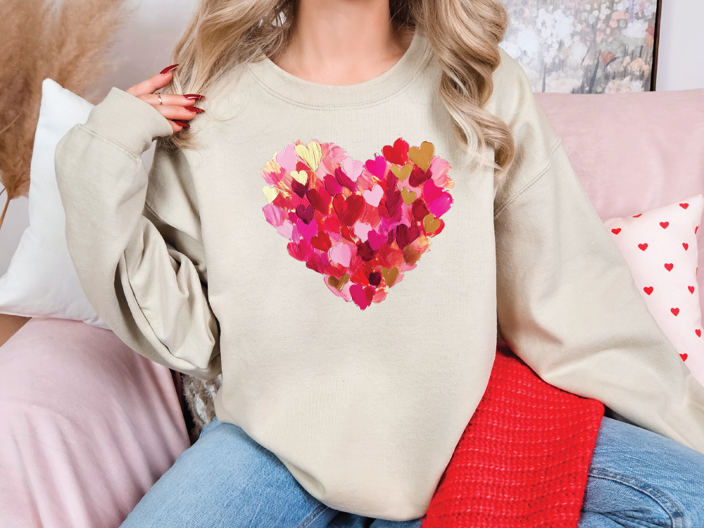 a woman sitting on a couch wearing a sweater with a heart painted on it