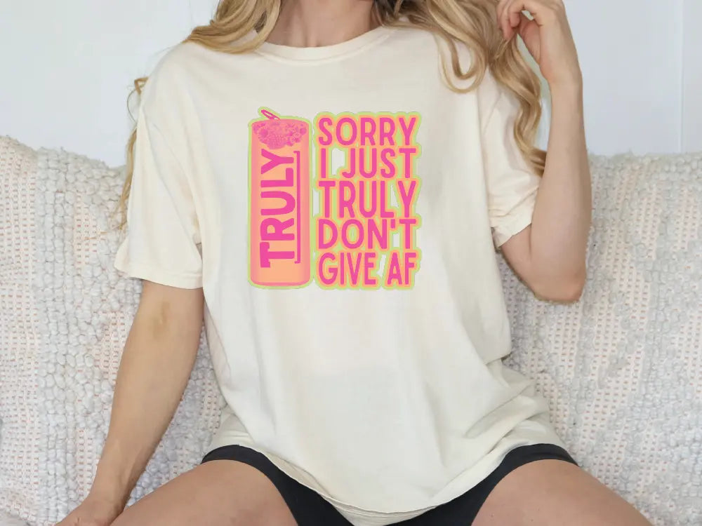 a woman sitting on a couch wearing a t - shirt that says sorry just truly