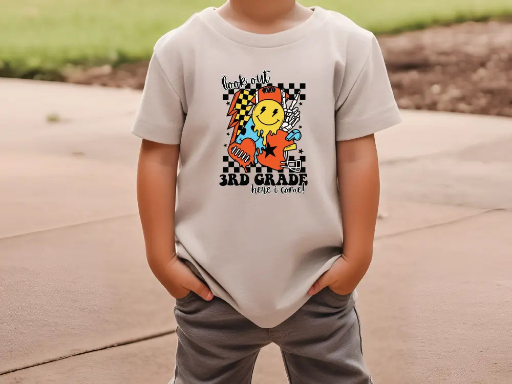 a young boy wearing a white shirt with a cartoon character on it