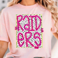 A woman wearing a pink t-shirt with the word "RAIDERS" printed on it in a bold, pink font.