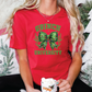 a woman in a red shirt sitting next to a christmas tree