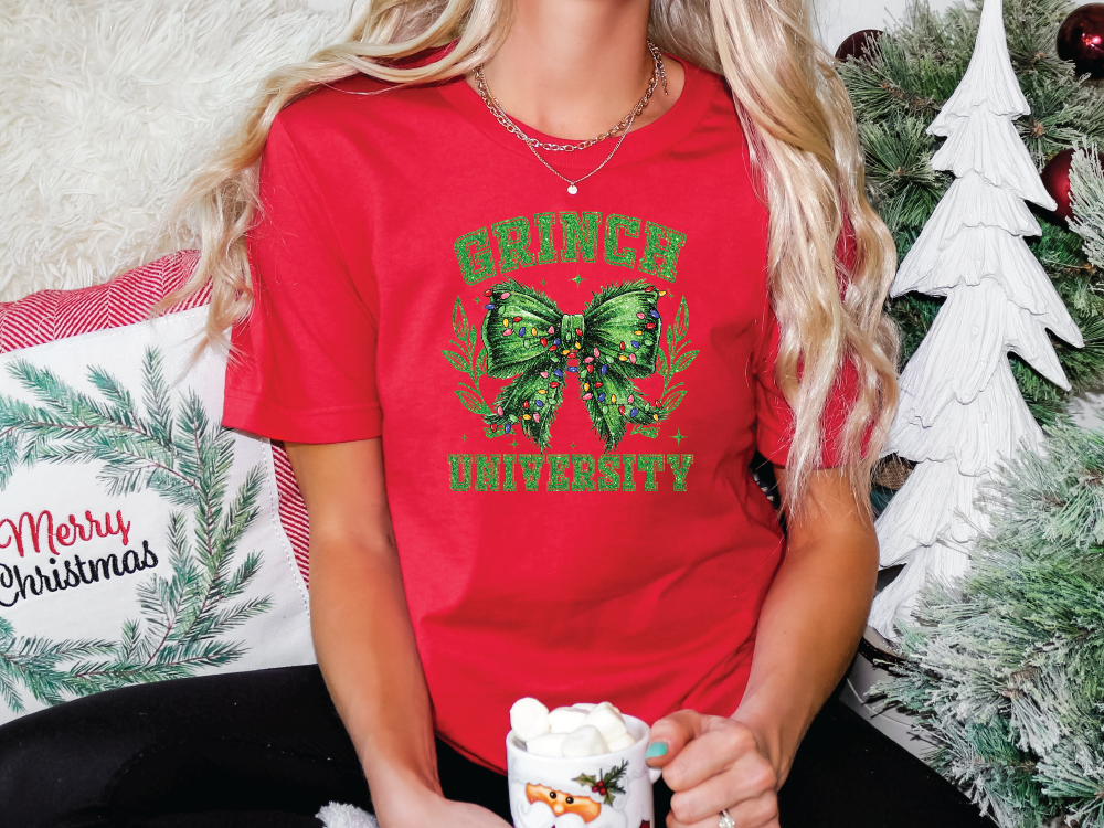 a woman in a red shirt sitting next to a christmas tree