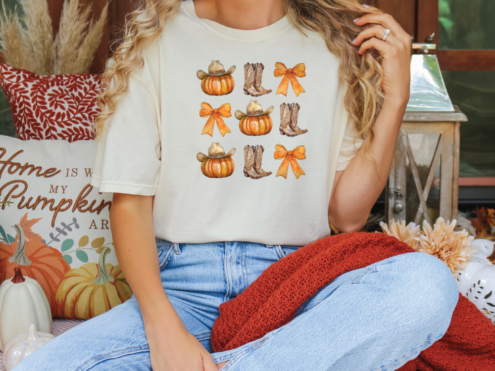 a woman sitting on a couch wearing a t - shirt with pumpkins on it