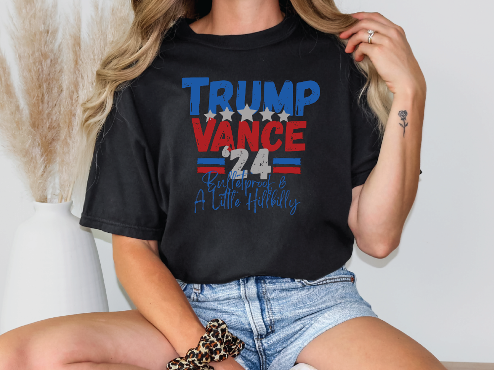 a woman sitting on a chair wearing a trump vance t - shirt